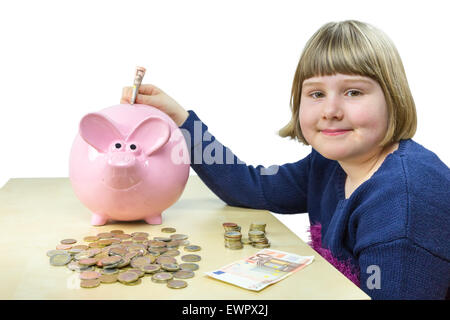 Kaukasische Mädchen mit Geld und Sparschwein auf Tisch isoliert auf weißem Hintergrund Stockfoto