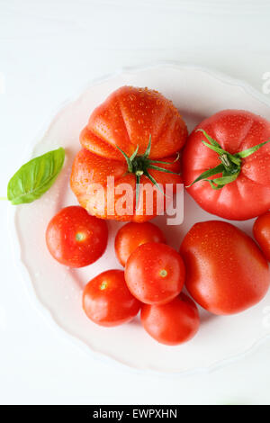 reife Tomate auf weißen Teller, Essen-Draufsicht Stockfoto