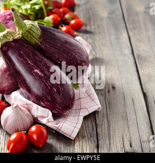 Auberginen und Tomaten auf rustikalen Holztisch. Stockfoto