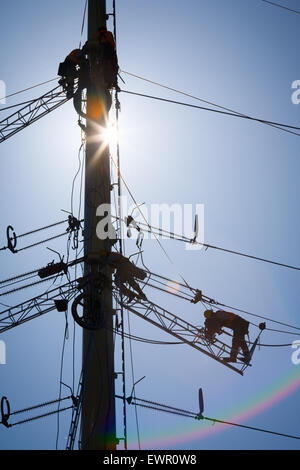 Arbeitnehmer, die eine industrielle Energie Hochspannungsleitung zu reparieren. Kein Gesicht ist sichtbar. Ideal für Energie, Sicherheit und Technik-Themen Stockfoto