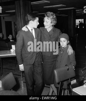 Olivia De Havilland am Flughafen von London mit ihren Kindern Benjamin und Gisele warten auf einen Flug nach Hause nach Paris. 15. April 1964. Stockfoto