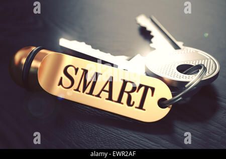 Smart - Schlüsselbund mit Text auf goldenen Schlüsselanhänger. Schwarzem Holz. Detailansicht mit selektiven Fokus. 3D Illustration. Stockfoto