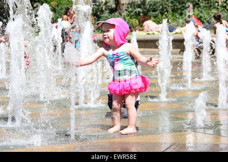 Sheffield, South Yorkshire, England. 30. Juni 2015. Kleinkinder abkühlen in den Wasserstrahlen eines öffentlichen Brunnens in Sheffield Peace Gardens bei heißem Wetter. Bildnachweis: Deborah Vernon/Alamy Live-Nachrichten Stockfoto