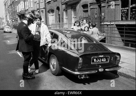 Rolling Stones: 28. August 1966 Mick Jaggers nachtblauen Aston Martin DB6 Kollision mit einem Fahrzeug von Kraft Foods in großen Titchfield Street, London beteiligt war. Jaggers Freundin Chrissie Shrimpton schaut zu, wie Mick seine Angaben durch ein p genommen hat Stockfoto