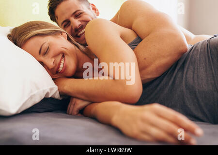 Bild von niedlichen jungen Liebespaar auf Bett liegend. Mann seine Frau morgens aufwachen.