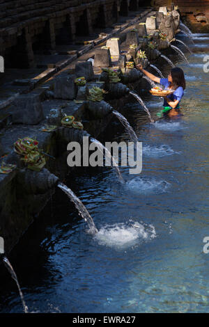 Eine Frau bereitet heilige balinesische Hindu-Gaben an den Tirta-Empul-Quellen in Tpaksiring, Bali, Indonesien, zu. Stockfoto