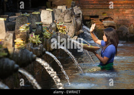 Eine Frau bereitet heilige balinesische Hindu-Gaben an den Tirta-Empul-Quellen in Tpaksiring, Bali, Indonesien, zu. Stockfoto