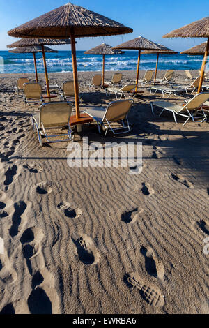 Schritte am Strand mit Strohschirmen und Liegestühlen Rethymno Kreta Griechenland Sandstrand Europa Stockfoto