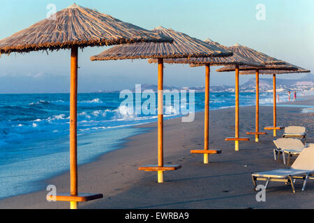 Stroh Sonnenschirme in Reihe Rethymno, Kreta, Griechenland Strand Europa Stockfoto