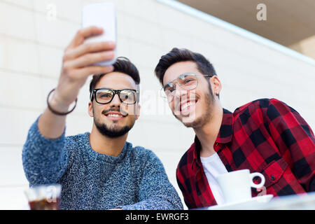 Outdoor-Porträt der beiden Jungunternehmer unter einem Selfie im Coffee Shop. Stockfoto