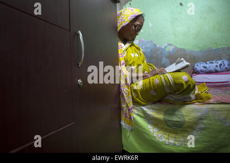 Dhaka, Bangladesch. 30. Juni 2015. Eine alte Frauen von Genf Camp lesen Koran in ihrem Haus in Ramadan.The Genf Camp für "gestrandet Pakistaner '' (Herkunft: der Staat Pakistan) ist in Mohammadpur. Pakistaner lebe dort seit Ende 1971 Krieg der Befreiung. © Zakir Hossain Chowdhury/ZUMA Draht/Alamy Live-Nachrichten Stockfoto