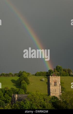 Regenbogen und schwarzen Himmel, Himmel während eines starken Regenschauers über Str. Marys Kirche, in der Stadt von Llanfair Caereinion,Powys,Wales,U.K. Stockfoto