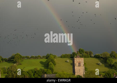 Regenbogen und schwarzen Himmel, Himmel während eines starken Regenschauers über Str. Marys Kirche, in der Stadt von Llanfair Caereinion,Powys,Wales,U.K. Stockfoto