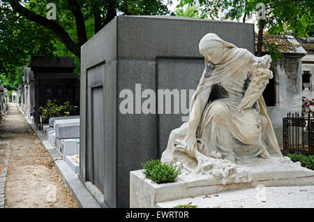 Die Statue einer Frau in Trauer legt Blumen auf ein Grab im Friedhof Montmartre, Paris, Frankreich. Stockfoto