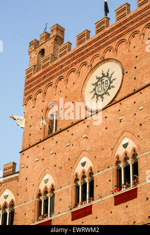 Siena ist in 17 Contrade Nachbarschaft Bezirke unterteilt und die Nachbarschaften sind klar definiert. Die Balkone und Ständen rund um den Platz für den Palio Monate im Voraus ausverkauft und sind extrem teuer. Für den durchschnittlichen Touristen versammeln sie sich in der Mitte die ist kostenlos, aber beinhaltet eine lange Wartezeit ohne WC-Anlagen in der Sonne. Betrachten das Palio-Pferderennen vom Gemauertes Rathaus mit Blick auf Piazza Campo (Campo Platz) Siena Palio-Pferderennen beobachten. In der zentralen Siena, Toskana. Italien. Juli. Stockfoto