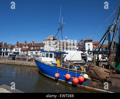 Fischkutter in Lymington Quay mit Geschäften und Restaurants im Hintergrund abgebildet Stockfoto