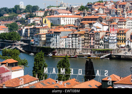 Blick auf mittelalterliche Stadtteil Ribeira am nördlichen Ufer des Douro Flusses von Vila Nova De Gaia mit seinen Weinkellern, einschließlich der berühmten Sandeman Keller. Porto, auch bekannt als Porto ist die zweitgrößte Stadt in Portugal. Liegt an der Mündung des Flusses Douro im Norden Portugals, Porto ist eines der ältesten europäischen Zentren und als Weltkulturerbe von der UNESCO eingetragen. Porto, Portugal. Stockfoto