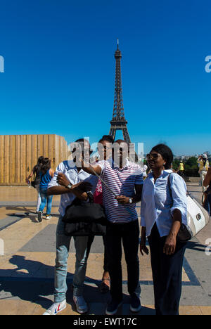 Paris, Frankreich. Menschen, die genießen Hitzewelle im Sommer, am Eiffelturm, afrikanische touristischen Familie Selfies fotografieren Stockfoto