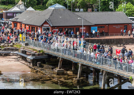 Passagiere warten in Brodick Pier an Bord der Arran Ferry, während andere aussteigen. Ticket / Tourist Info Büros im Hintergrund Stockfoto