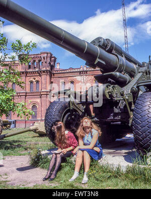 Leningrad, Russland. 24. Juni 1989. Zwei junge Mädchen nehmen Sie die Sonne unter einem veralteten Kanone auf dem Display in der UdSSR Verteidigung Ministerium für historische militärische Museum der Artillerie, Ingenieur & Signal Truppen in Leningrad © Arnold Drapkin/ZUMA Draht/Alamy Live News Stockfoto