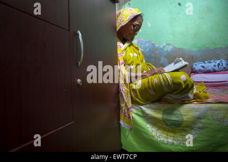 Eine alte Frauen von Genf Camp lesen Koran in ihrem Haus während des Ramadan. Genf-Camp für "Gestrandet Pakistanis" (Ursprung: der Staat Pakistan) ist in Mohammadpur. Pakistaner lebe dort seit Ende 1971 Krieg der Befreiung. Stockfoto