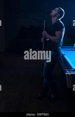 Junger Mann sucht verwirrt verlor seine Billard-Spiel Stockfoto