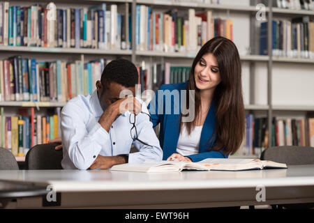 Schlafenden Studenten sitzen und stützte sich auf Stapel Bücher In der Schule - geringe Schärfentiefe Stockfoto