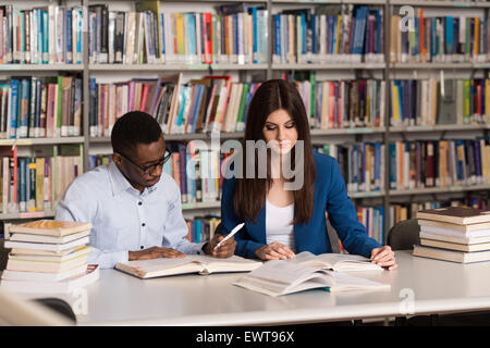 Schlafenden Studenten sitzen und stützte sich auf Stapel Bücher In der Schule - geringe Schärfentiefe Stockfoto