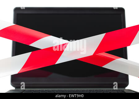 Zwei rote und weiße Barriere Bänder sind vor einem Computerdisplay gekreuzt. Die Zusammensetzung symbolisiert Beschränkung der Nutzung von der Stockfoto
