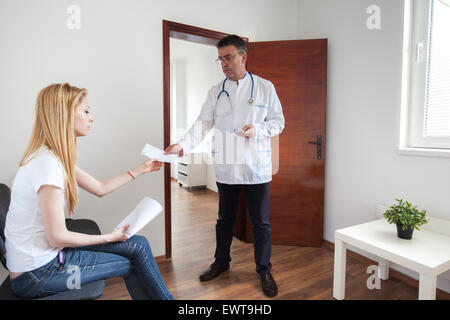 Arzt-Arzt ist ein Rezept mit geeigneter Medizin für seine Patienten in der Ordination geben. Stockfoto