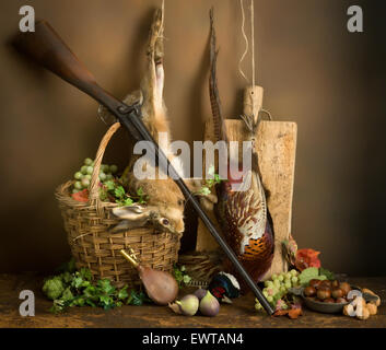 Herbstliche Stillleben mit Jagdgewehr, Fasan und Hase Stockfoto