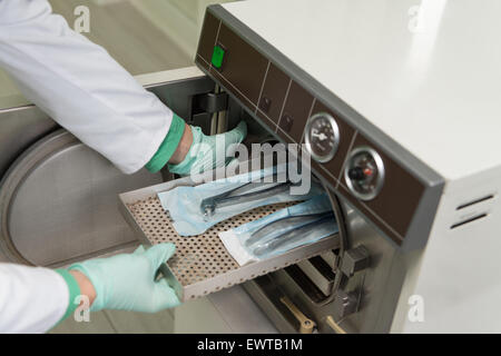 Junge Zahnärztin Orte medizinische Autoklav für die Sterilisation chirurgischer und andere Instrumente Stockfoto