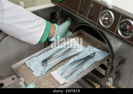 Junge Zahnärztin Orte medizinische Autoklav für die Sterilisation chirurgischer und andere Instrumente Stockfoto