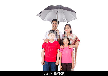 indische Eltern und Kinder Schutz Regenschirm Stockfoto