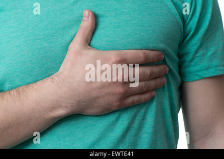 Junger Mann im Besitz einer Hand auf sein Herz durch diesen Schmerz - Over White Background, isoliert Stockfoto