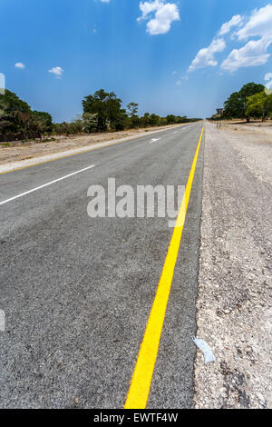 Endlose Straße in Namibia Caprivi Game Park, mit blauem Himmel Stockfoto