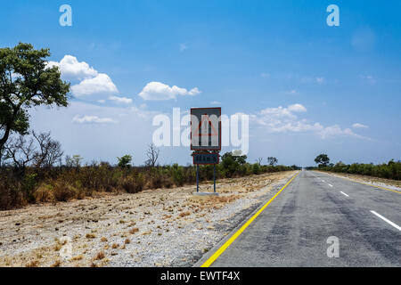 Endlose Straße mit blauen Himmel und Zeichen Elefanten überqueren in Namibia Caprivi Game Park, mit blauem Himmel Stockfoto