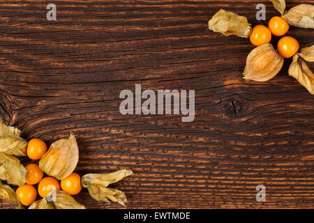 Physalis Hintergrund mit Exemplar. Boden-Kirsche auf rustikalen Holztisch, Top Aussicht. Gesundes Obst essen. Stockfoto