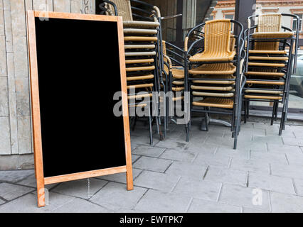 Leeres Menü zur Anzeige Text mit gestapelten cafe Stühle im Hintergrund Stockfoto
