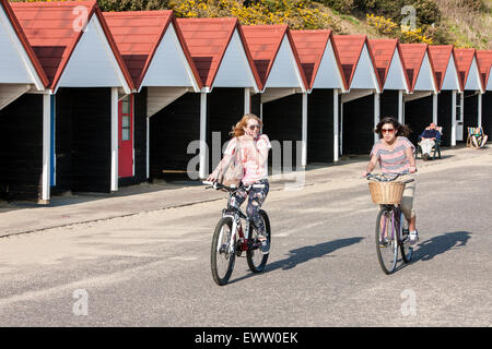 Sonnenbaden an sonnigen Frühlingstag am Strand Hütten am Strand von Bournemouth, Bournemouth Stadt Zentrum, Dorset, England, Europa. März. Stockfoto