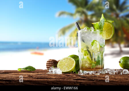 Exotischer Sommerdrink auf Holzbohlen serviert. Strand als Hintergrund Unschärfe Stockfoto