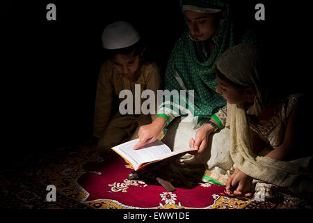 indische muslimische Mutter und Kinder Quran Buch lesen Stockfoto