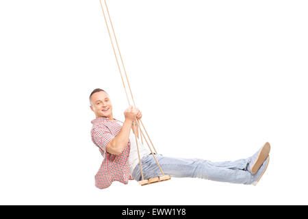 Profil-Studio erschossen von einem begeistert jungen Mann auf einer Holzschaukel Schaukeln und schaut in die Kamera, die isoliert auf weißem Hintergrund Stockfoto