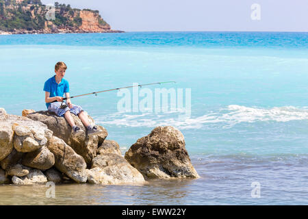 Kaukasische Teenager Angeln mit Rute in der Nähe von Meer und Strand Stockfoto