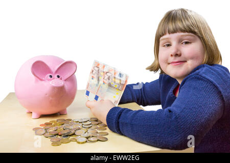 Junges Mädchen zeigt Geld Euronoten und-Münzen für Sparschwein isoliert auf weißem Hintergrund