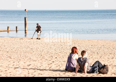 An einem sonnigen Frühlingstag, ein Detectorist mit Metalldetektor nach den meisten Touristen/Urlauber verlassen haben Strand auf der Suche nach verlorenen Gegenständen/Schatz Stockfoto