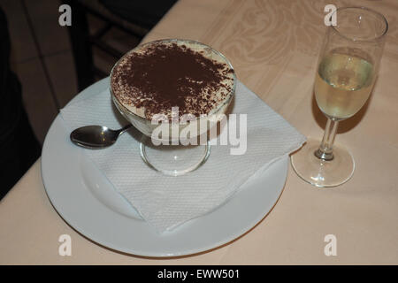 Schüssel mit Tiramisu Dessert und ein Glas süßen Weißwein. Stockfoto