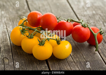 gelbe und rote Tomaten auf Holztisch Stockfoto
