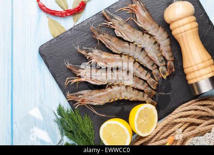 Frische rohe Riesengarnelen und Gewürzen auf Holztisch Stockfoto