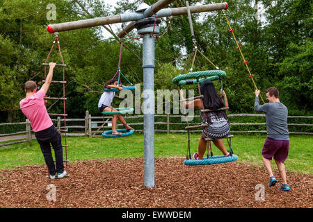 Eine Familie spielen auf Schaukeln, Play Area, Sussex, Großbritannien Stockfoto